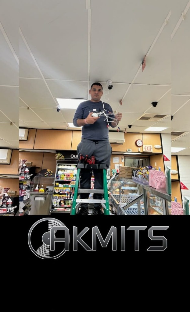 AKMITS Services Technician Installing Ceiling Security Cameras in Restaurant